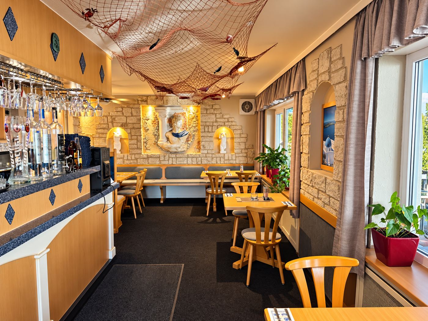 Bar mit Fischernetz an der Decke und Wandrelief